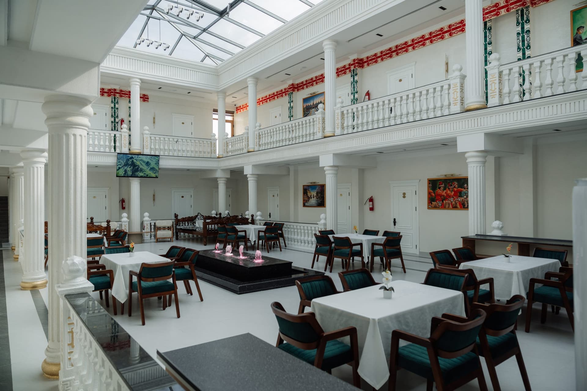 Atrium dining hall at Hotel Kampoeng Indonesia with set tables and central fountain, Samarkand